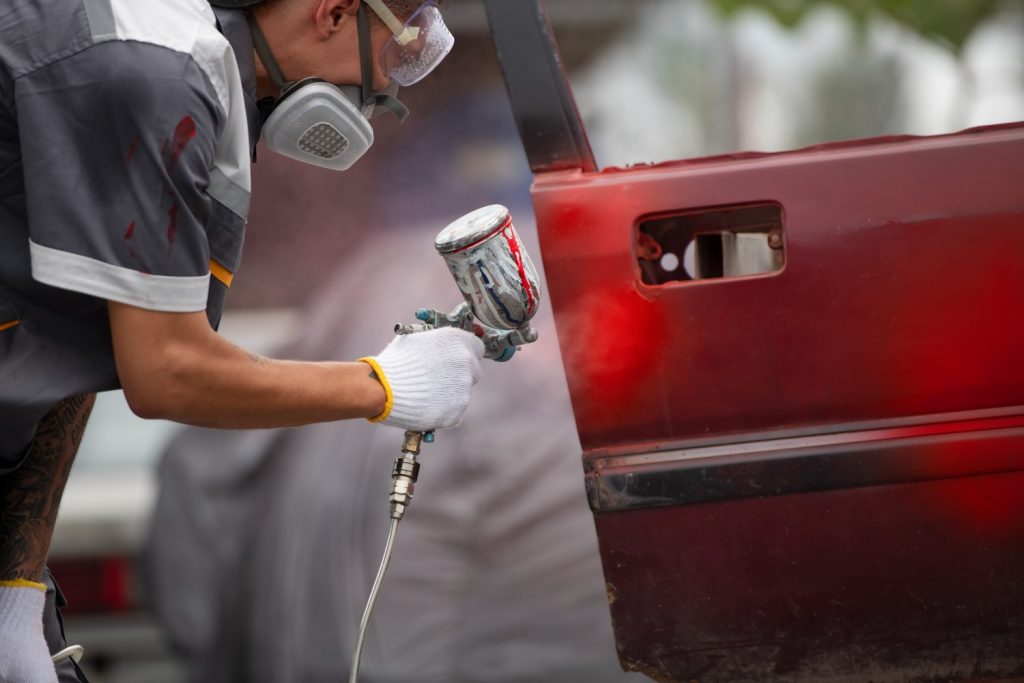 side-view-man-spraying-powder-paint-car-door